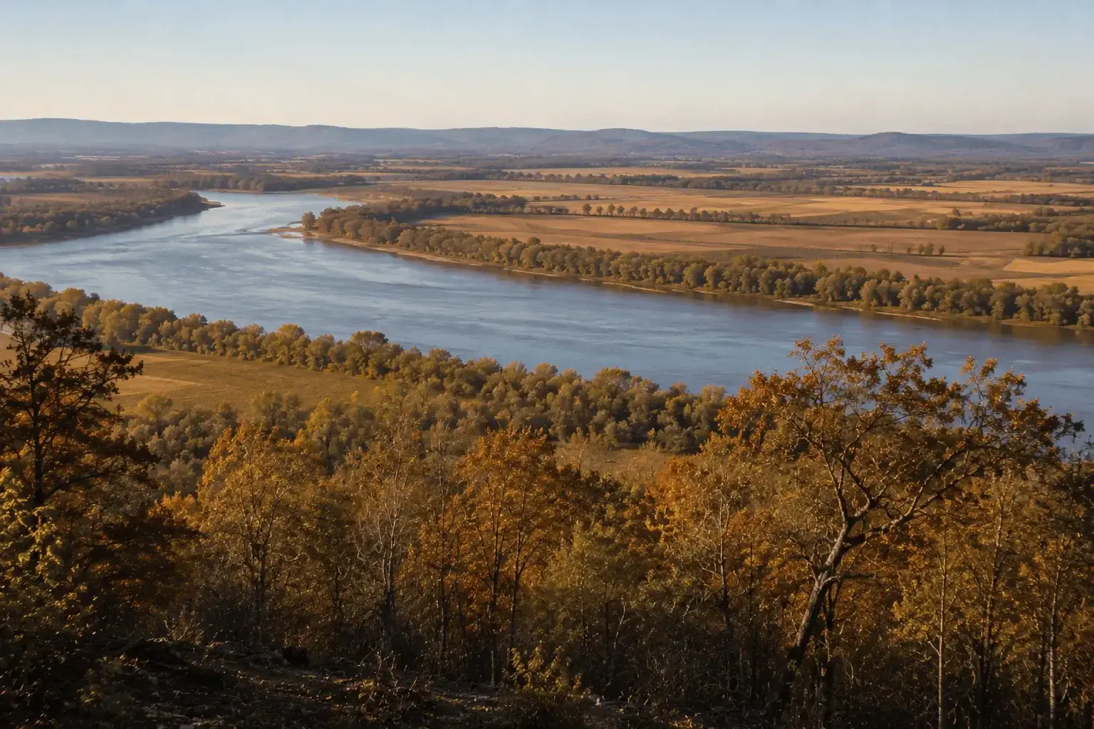 The Arkansas River winding through autumn bottomland and farm fields in the River Valley